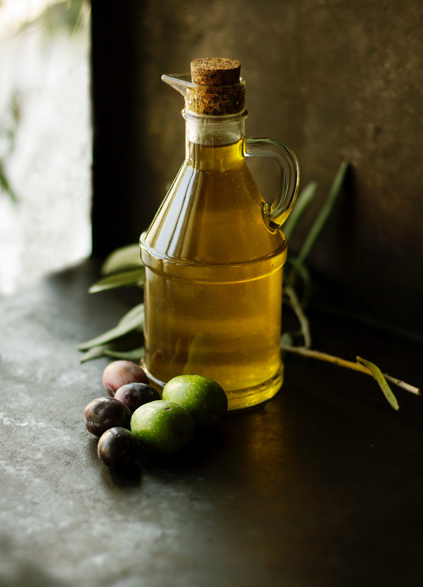 Casa Gomez extra vierge olijfolie fles met een paar olijven en olijftakjes