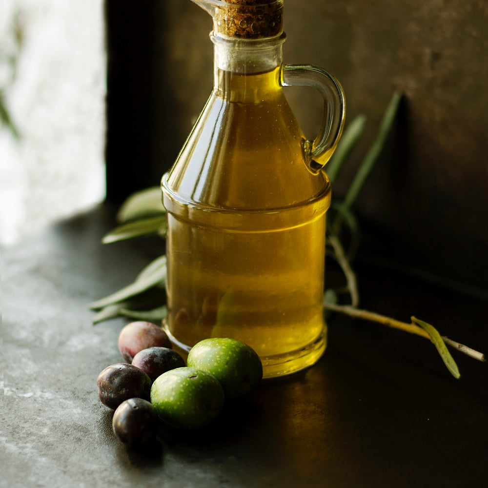Casa Gomez extra vierge olijfolie fles met een paar olijven en olijftakjes